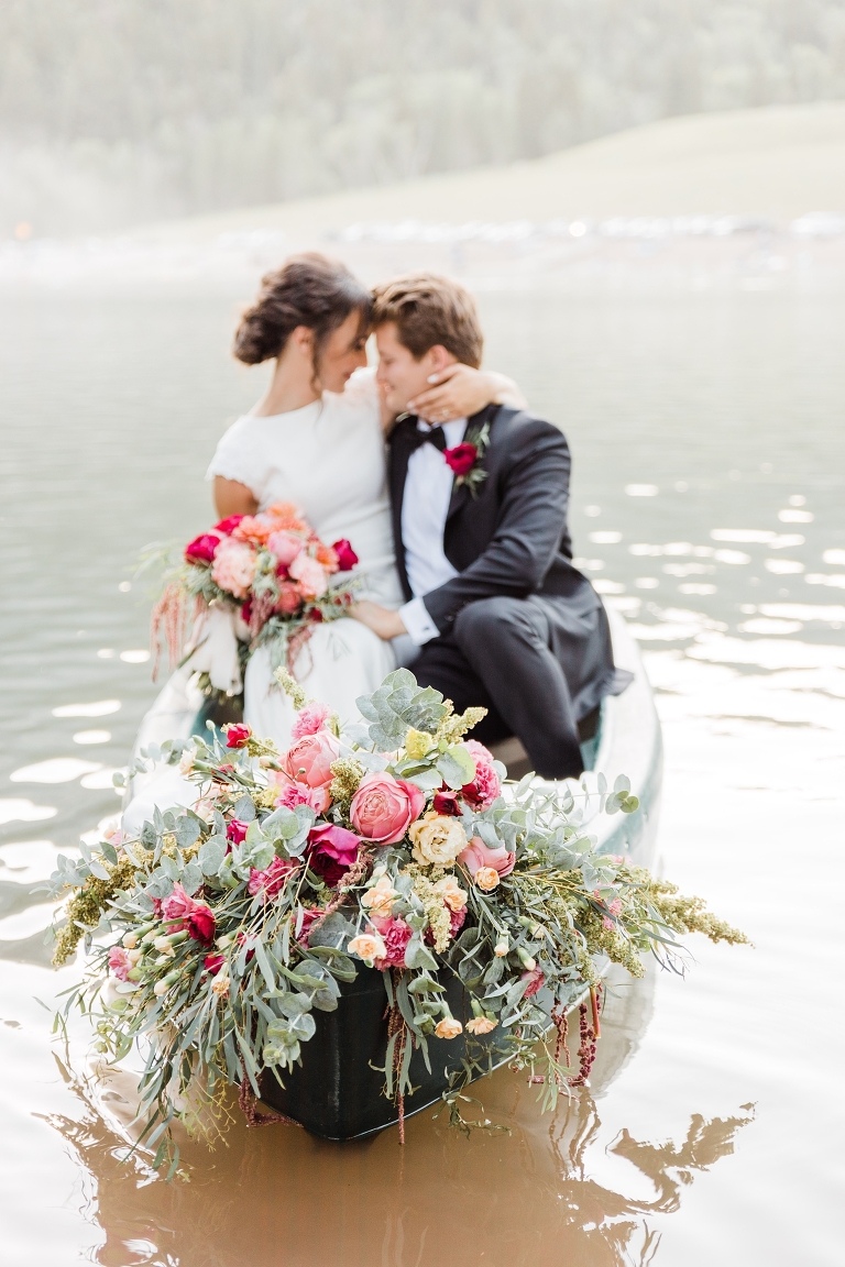 Tibble Fork Reservoir Couple in a Canoe, Utah Wedding Photography, Bride and Groom on lake, bright pink flowers greenery floral design